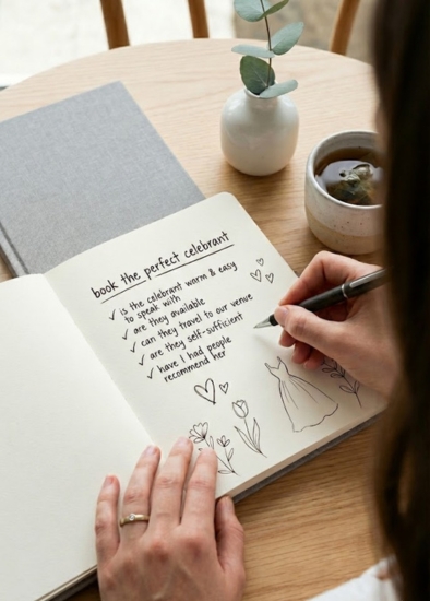 A bride-to-be writing in her wedding planning diary with a checklist for booking the perfect celebrant in Castlemaine.