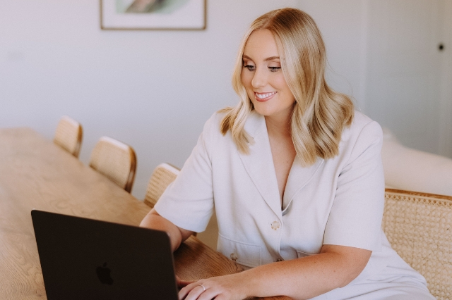 Cassie Argus, a meticulous Central Victoria wedding celebrant, typing on her laptop in her home office to promptly answer a couple's enquiry.