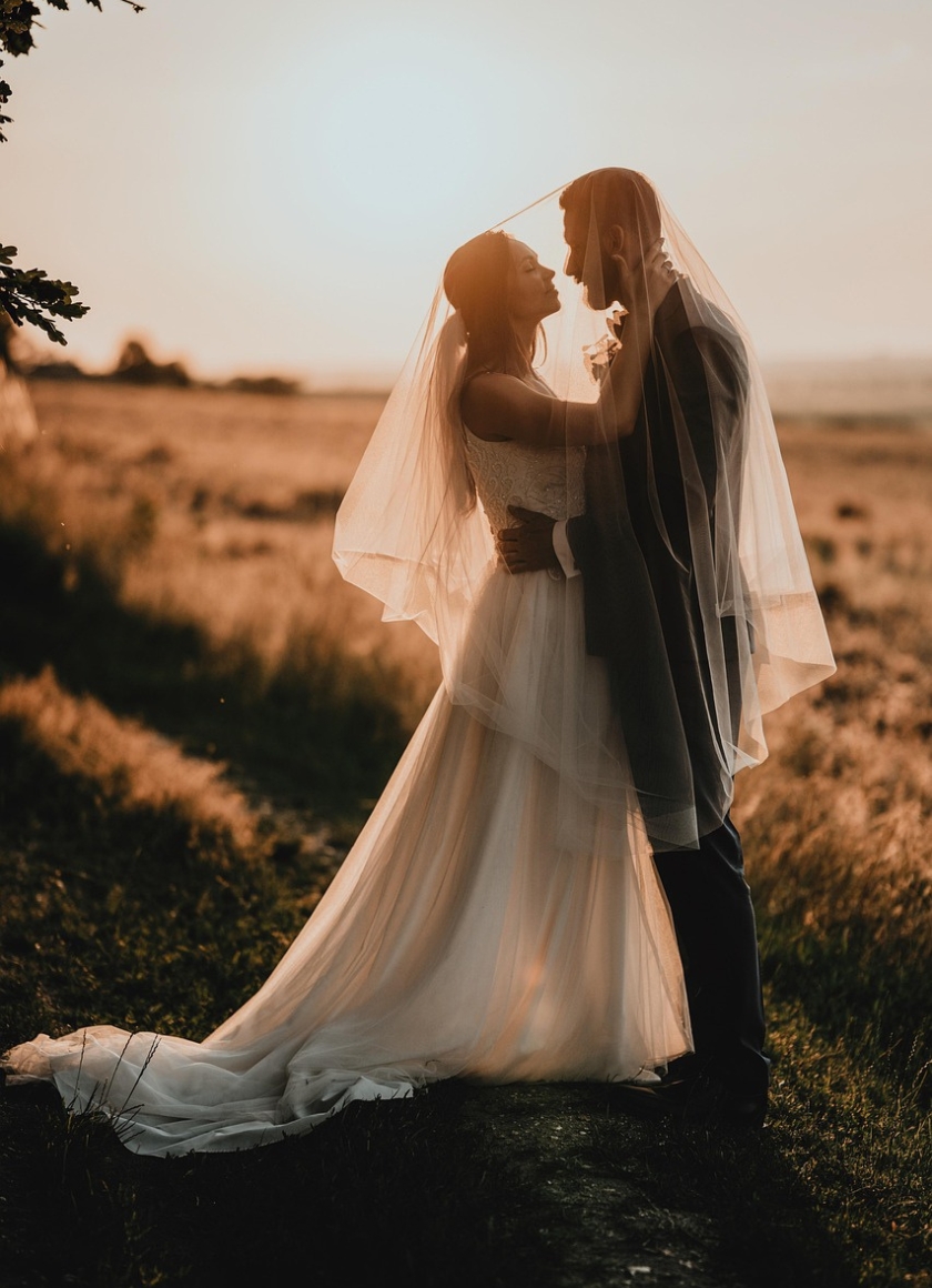 A newlywed couple looking at each other romantically during a beautiful sunset rural wedding ceremony in Bendigo.